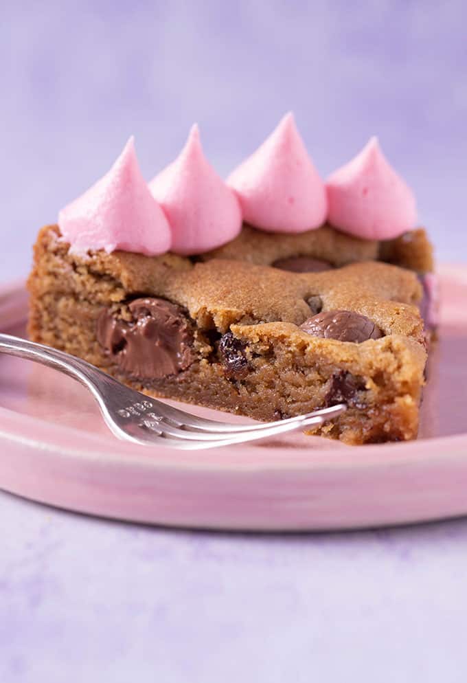 A slice of Easter Egg Cookie Cake on a purple background