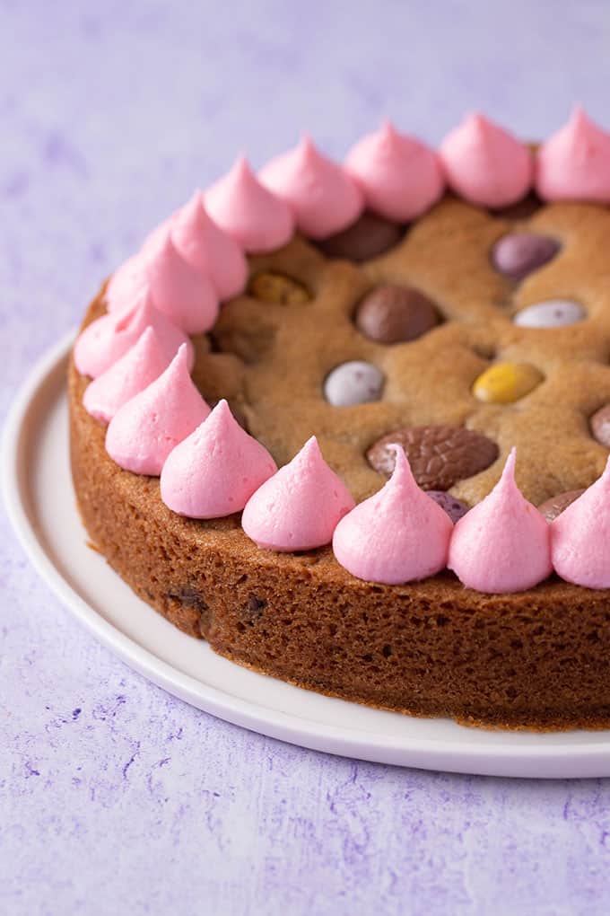 A large Easter Egg Cookie Cake with pink frosting piped around the edges