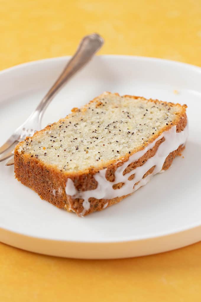 Close up of a piece of Lemon Poppy Seed Bread on a white plate 