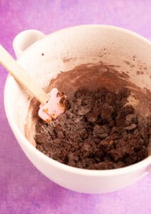 Chocolate cookie dough in a white mixing bowl.