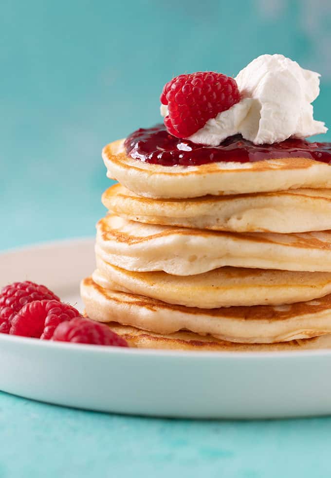 A stack of homemade Pikelets topped with jam and cream