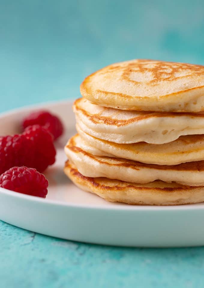 A stack of homemade Pikelets served with fresh raspberries