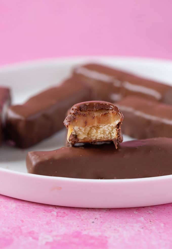 Homemade Twix Bar with a bite taken out of it to show the chewy caramel centre.