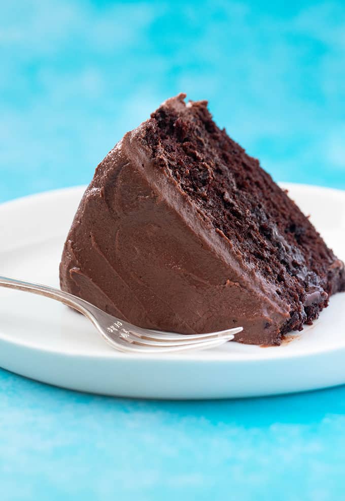 A slice of Vegan Chocolate Cake on a white plate
