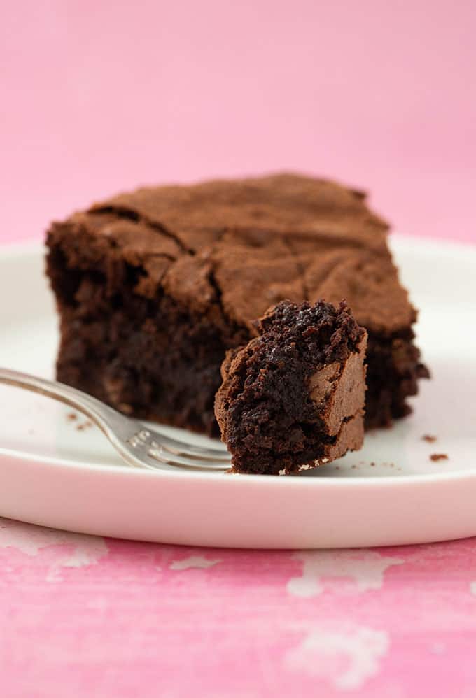 A slice of Brownie Cake with a bite taken out of it