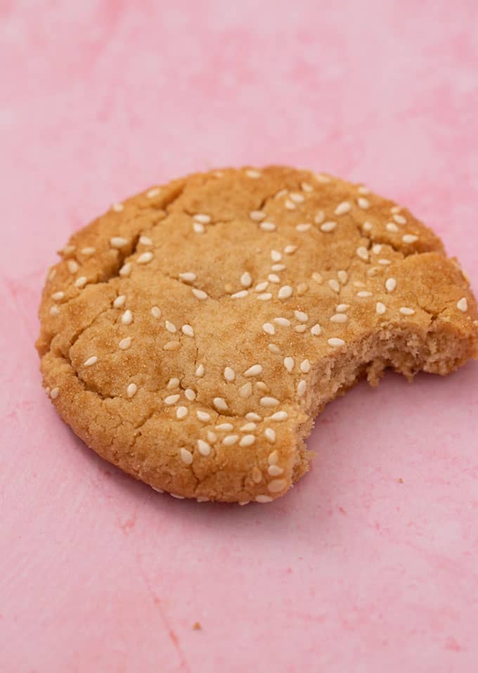 A single Tahini Cookie with a bite taken out of it