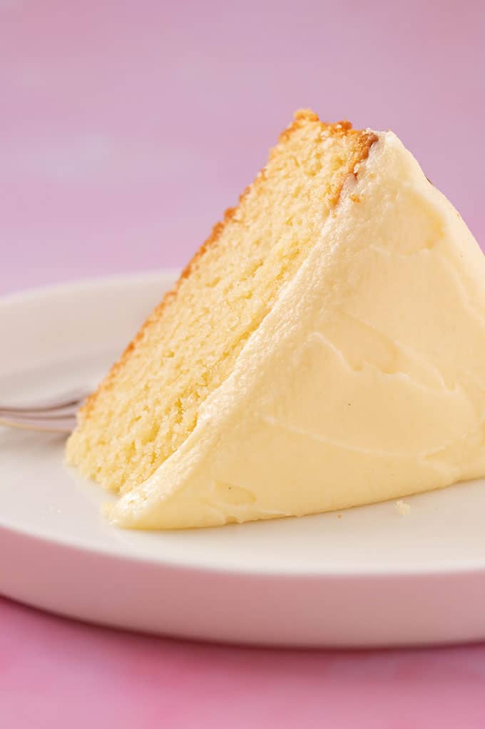 A big slice of homemade cake with a thick layer of frosting.