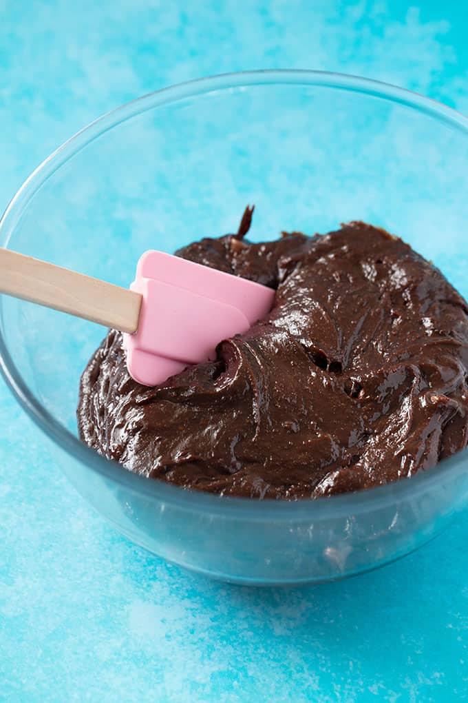 A glass bowl filled with chocolate brownie batter