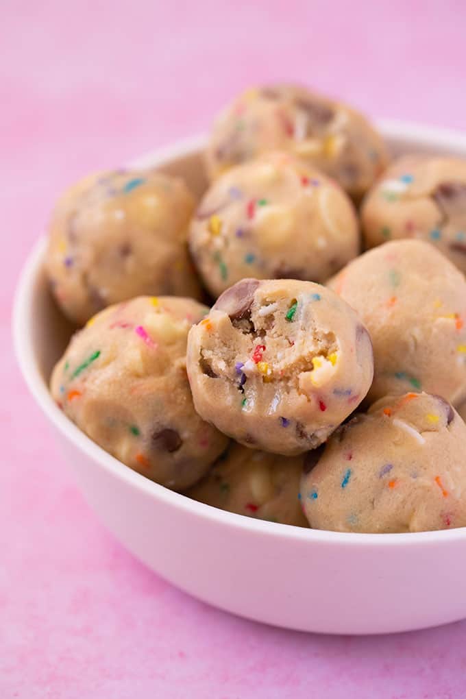 A white bowl filled with cookie dough balls 