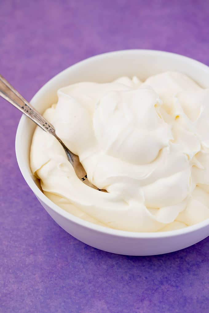 A white bowl filled with softly whipped cream