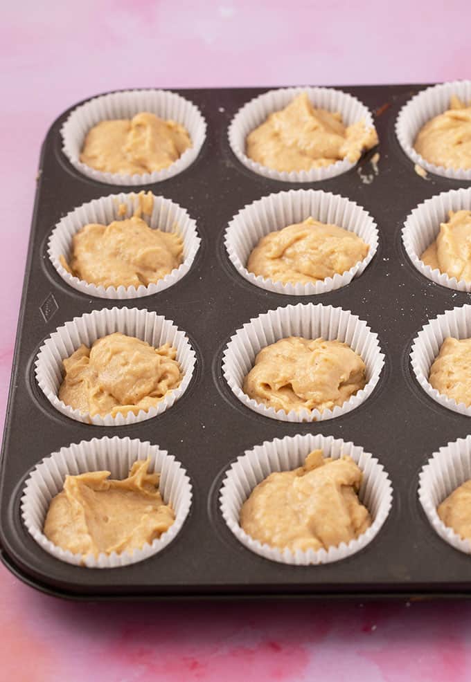 A muffin pan filled with banana cupcake batter ready to go in the oven