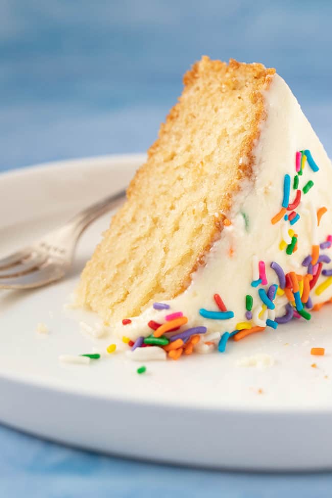 A slice of Vegan Vanilla Cake on a blue background