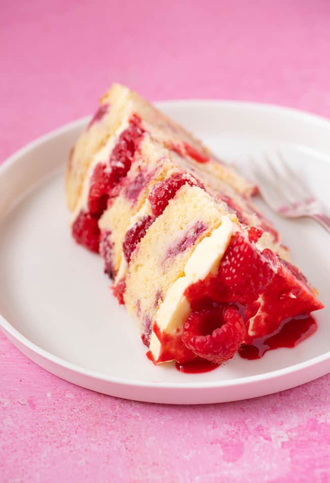 A close up of a piece of Raspberry Ripple Cake on a pink background