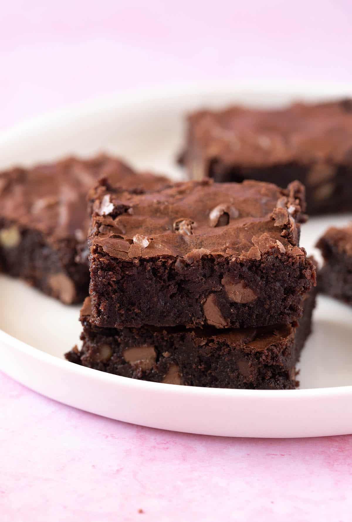 A stack of homemade Chocolate Brownies on a white plate