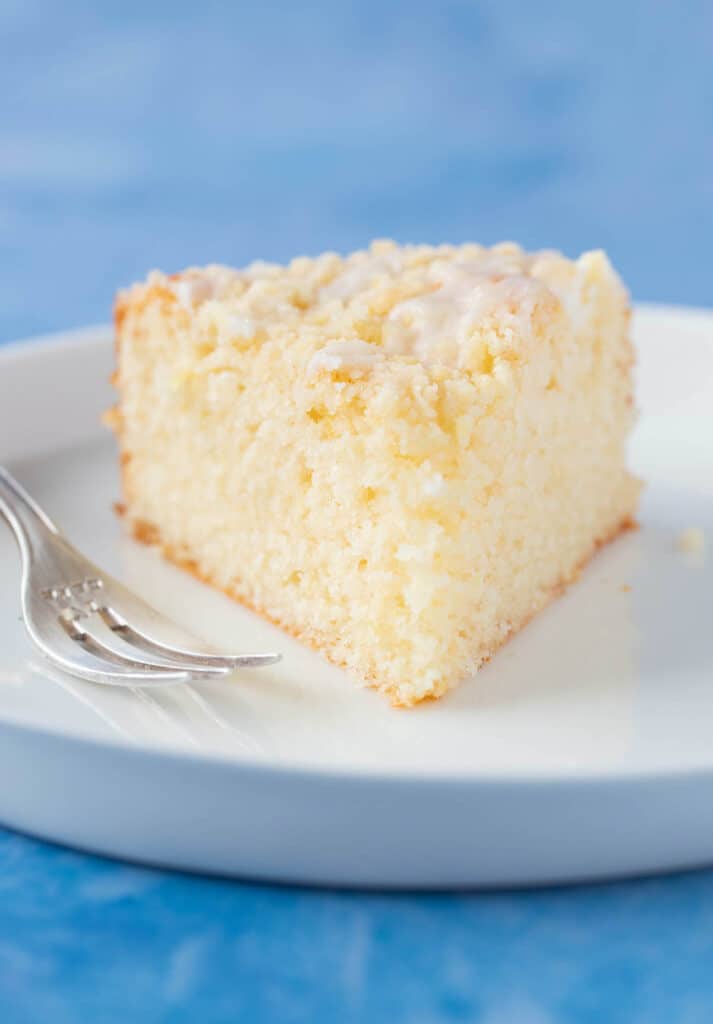 Close up of a big slice of Lemon Crumb Cake on a white plate