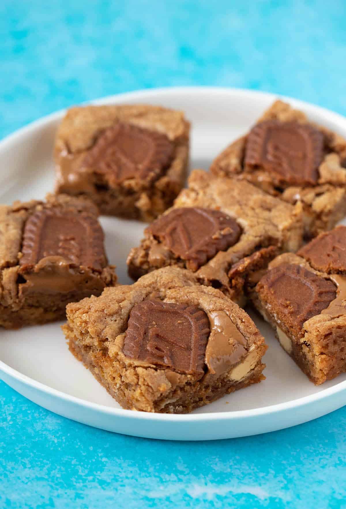 A plate of Biscoff Blondies on a blue background. 