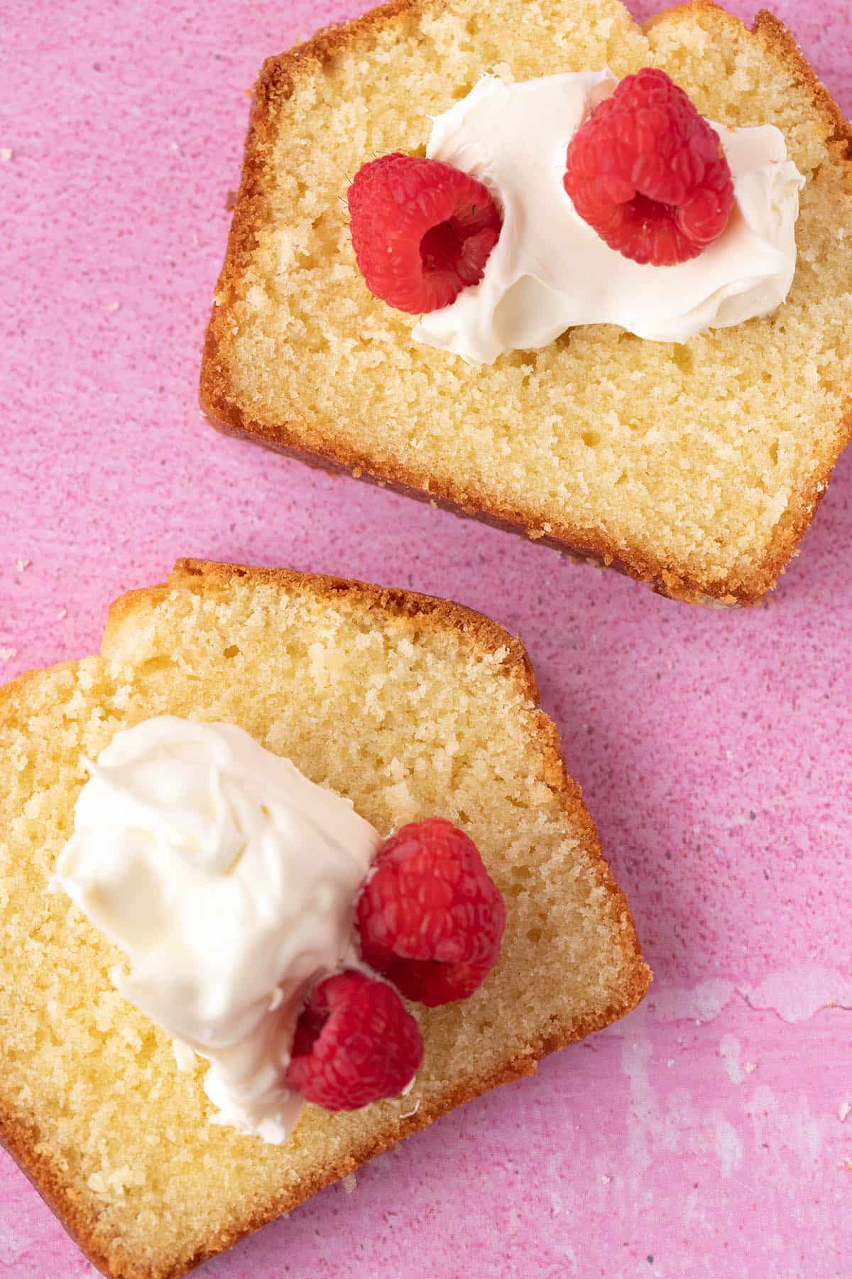 Top view of a slices of Pound Cake topped with cream and berries