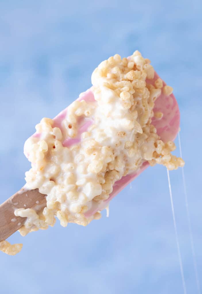 A pink spatula covered in sticky marshmallow