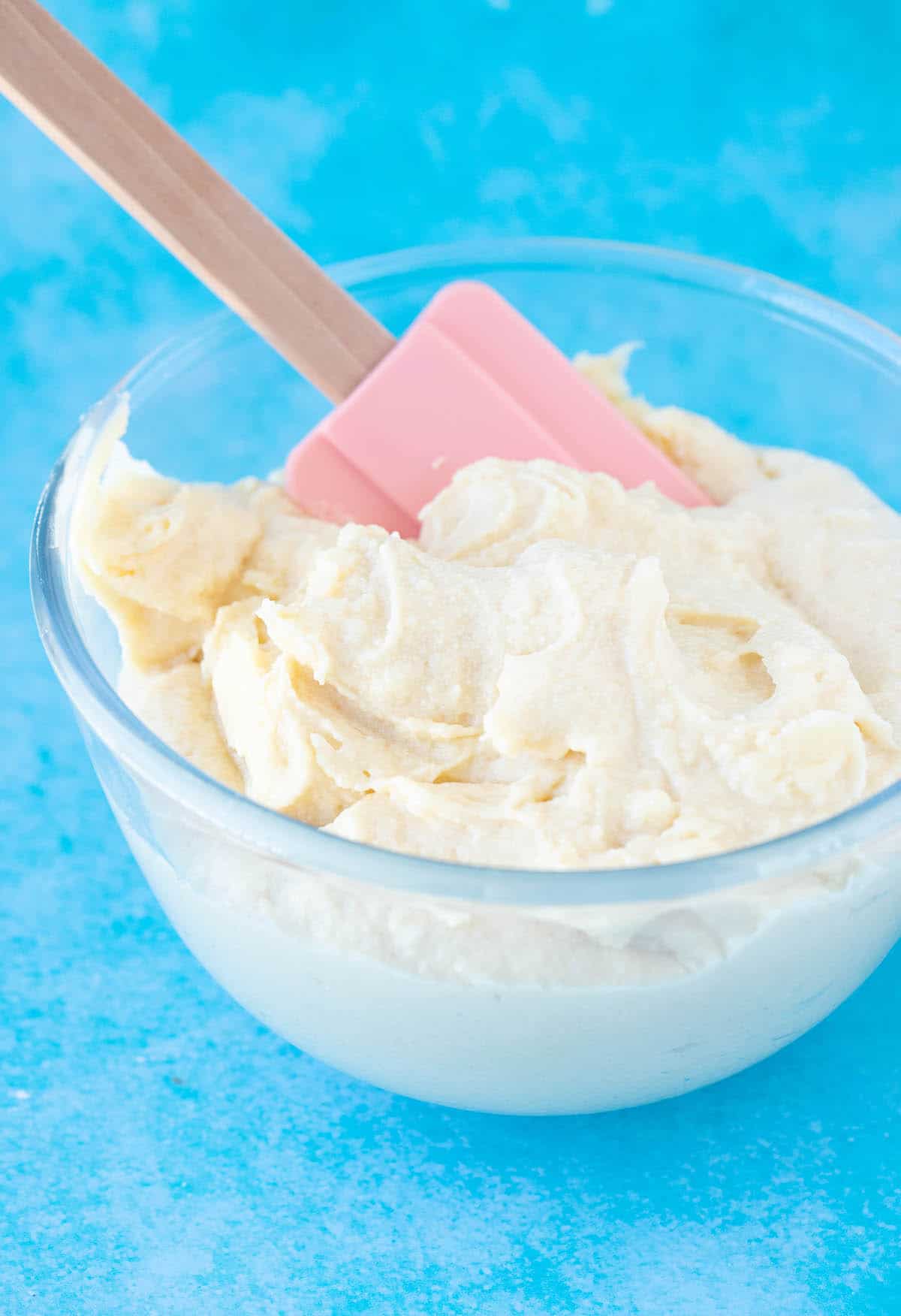 A glass bowl full of thick and creamy cake batter