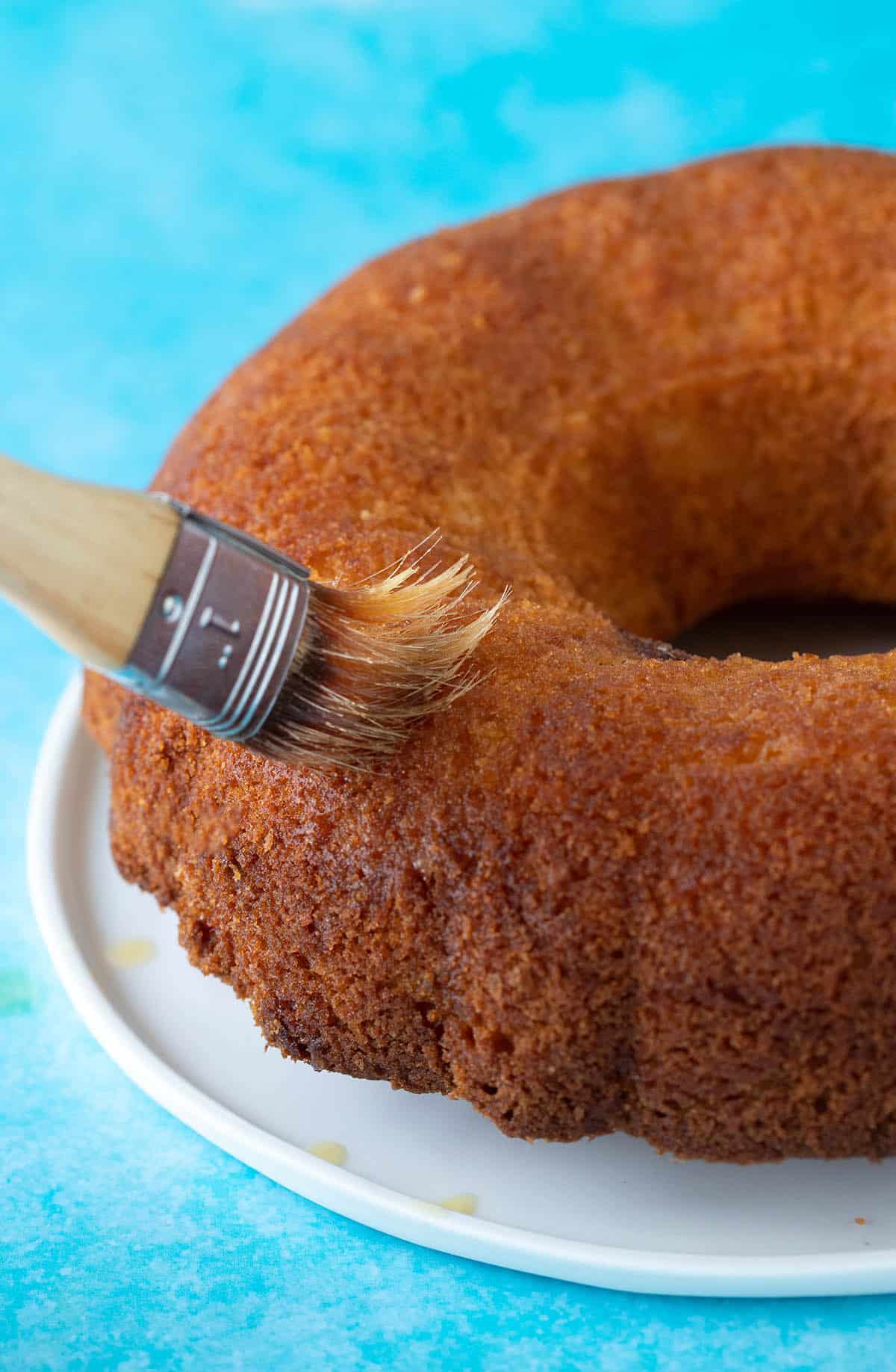 A butter cake being brushed with butter 