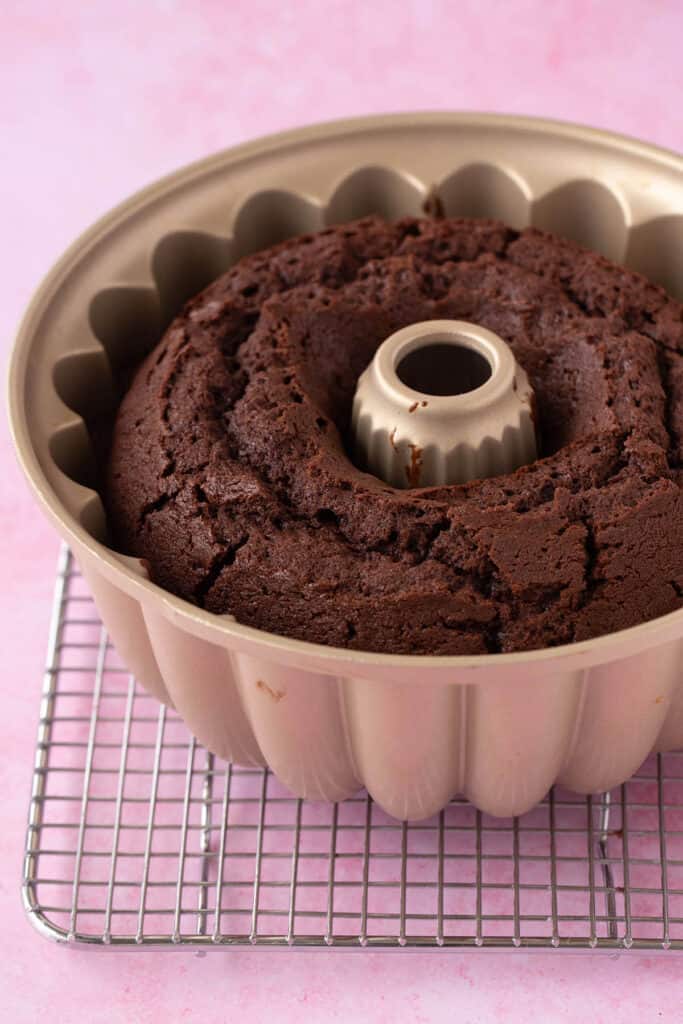 A chocolate pound cake fresh from the oven sitting on a cooling rack