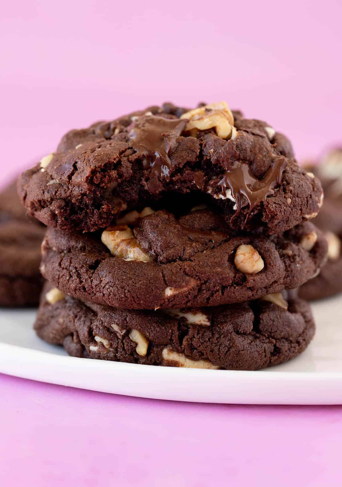 A stack of Chunky Walnut Chocolate Cookies on a white plate