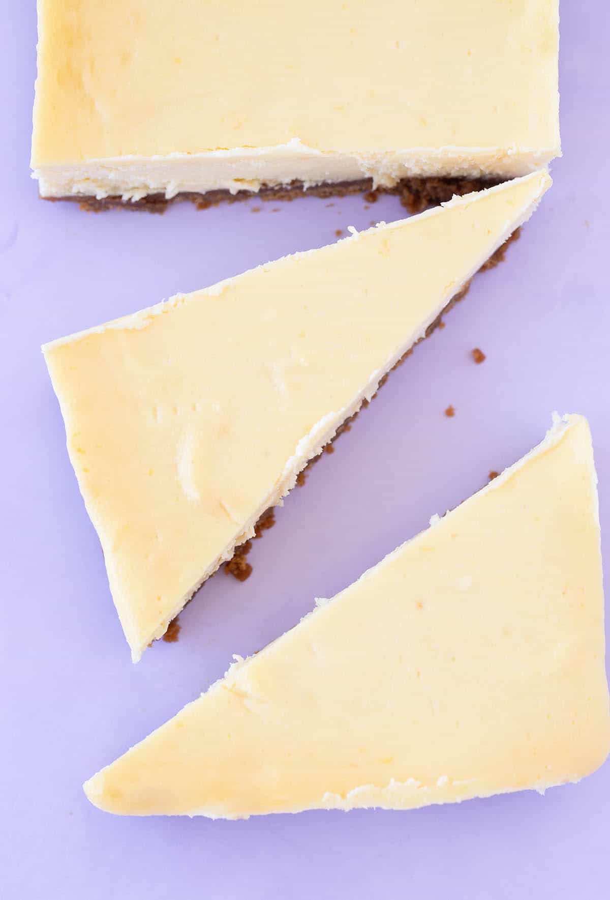Top view of slices of cheesecake on a purple background 