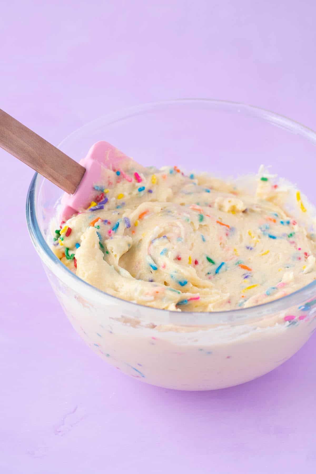 A glass bowl filled with cupcake batter.