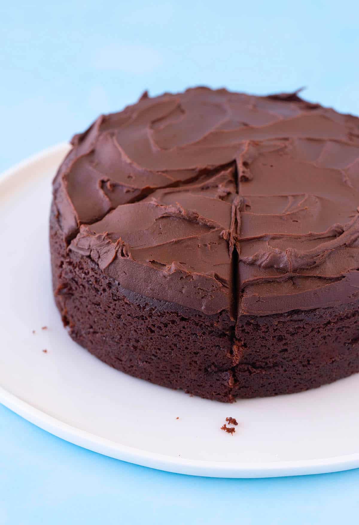A small homemade Chocolate Cake with a slice cut out of it