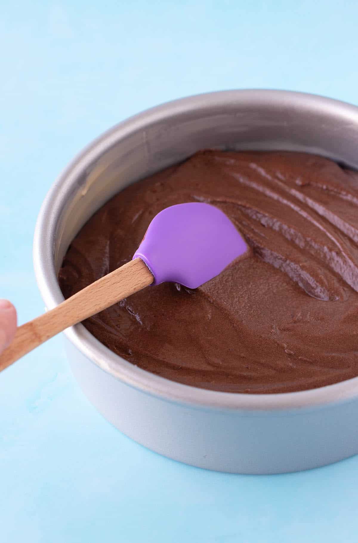 A cake pan filled with chocolate cake batter ready to go in the oven