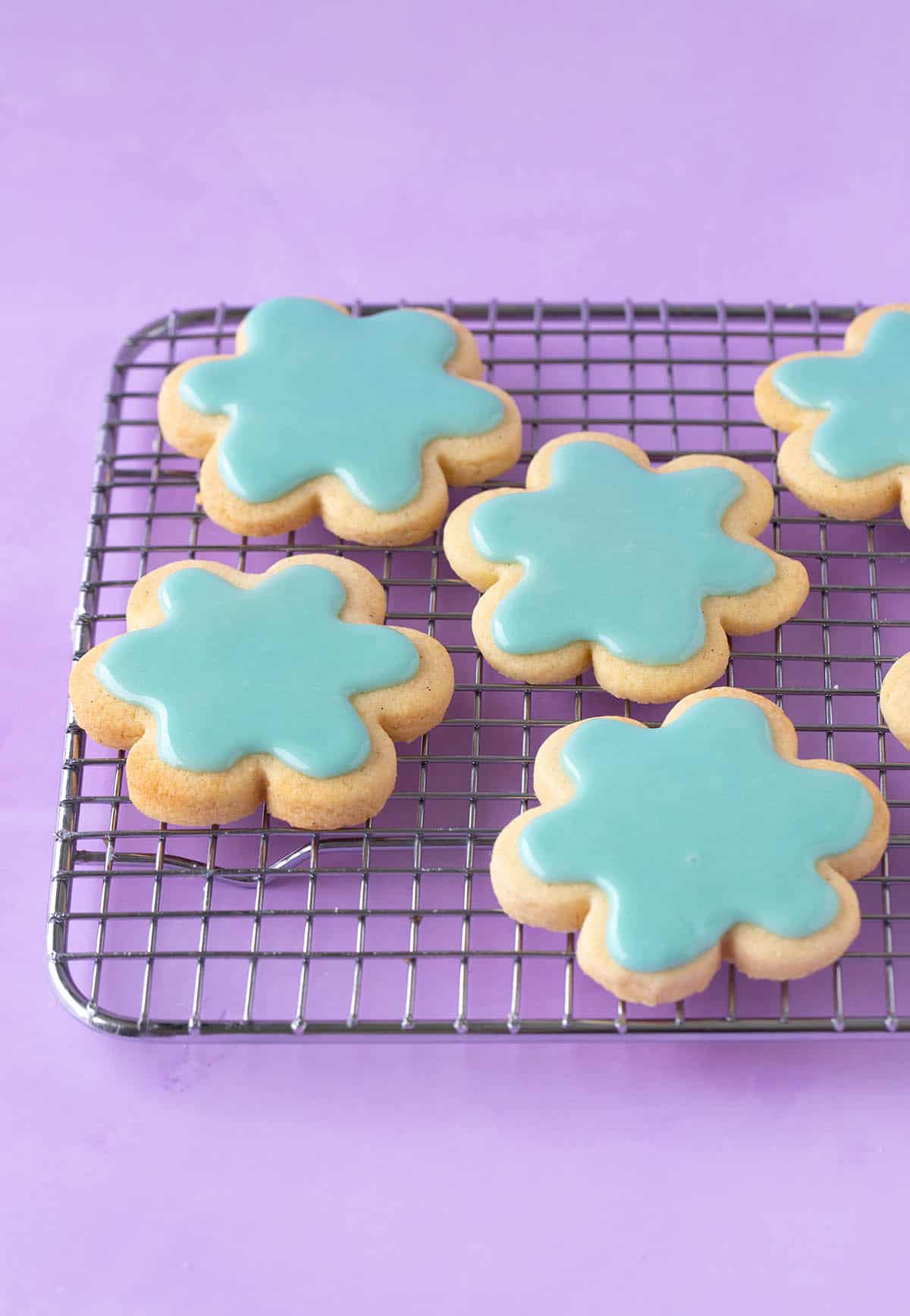 Flower-shaped Sugar Cookies covered in a green icing sugar glaze.