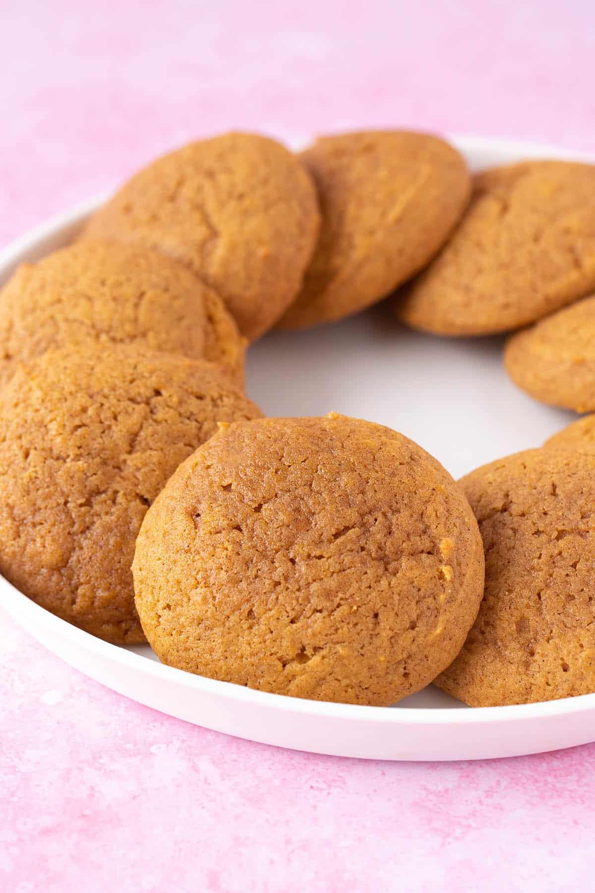 A plate of homemade Pumpkin Cookies on a pink background.