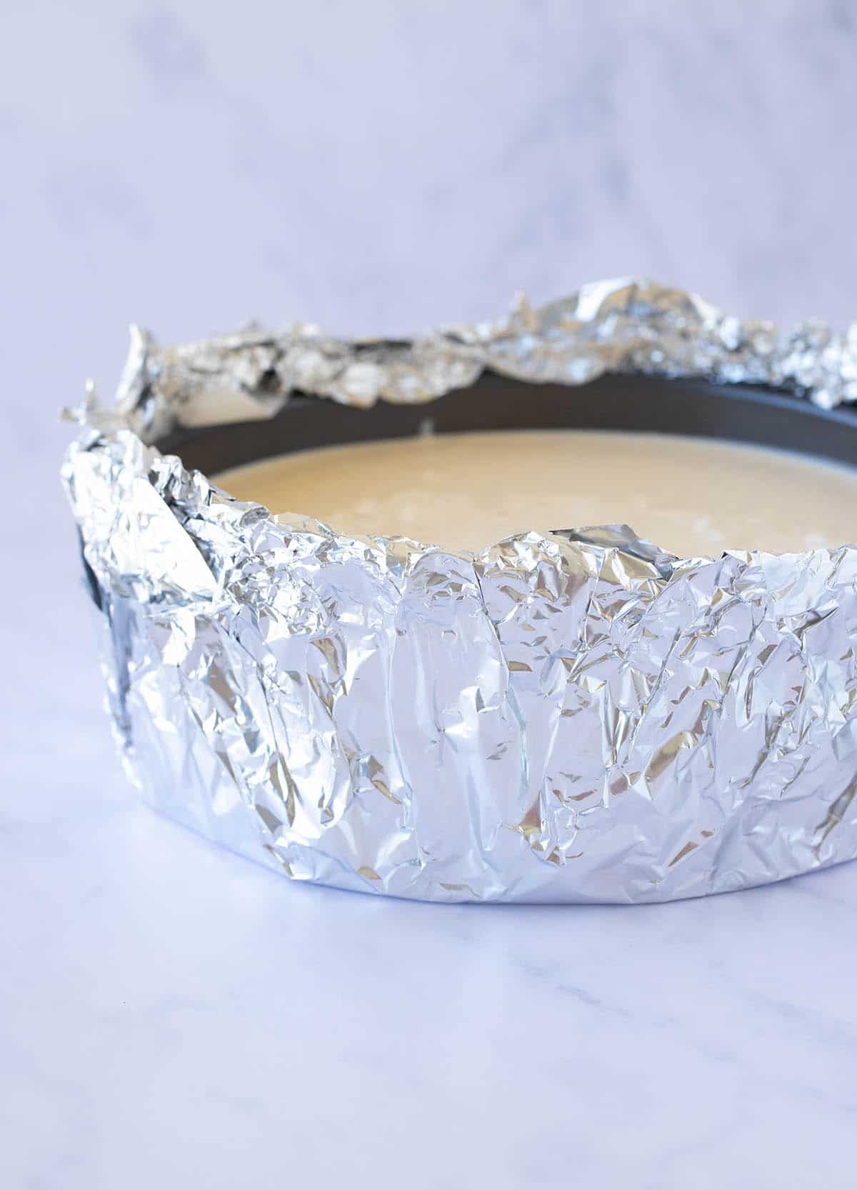 Showing how to make a water bath: A cheesecake wrapped in aluminium foil 