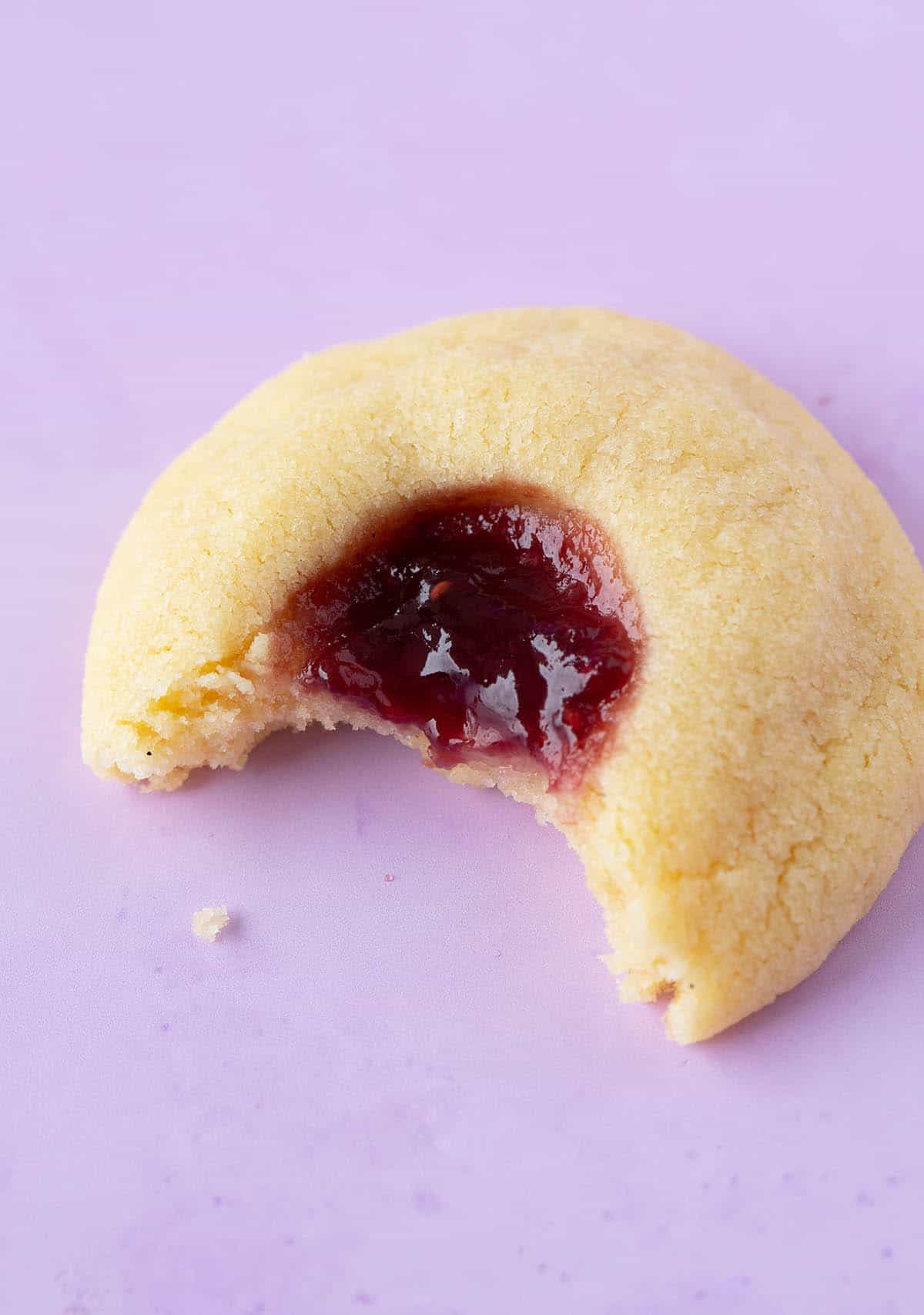 A homemade Jam Drop Cookies with a bite taken out of it.