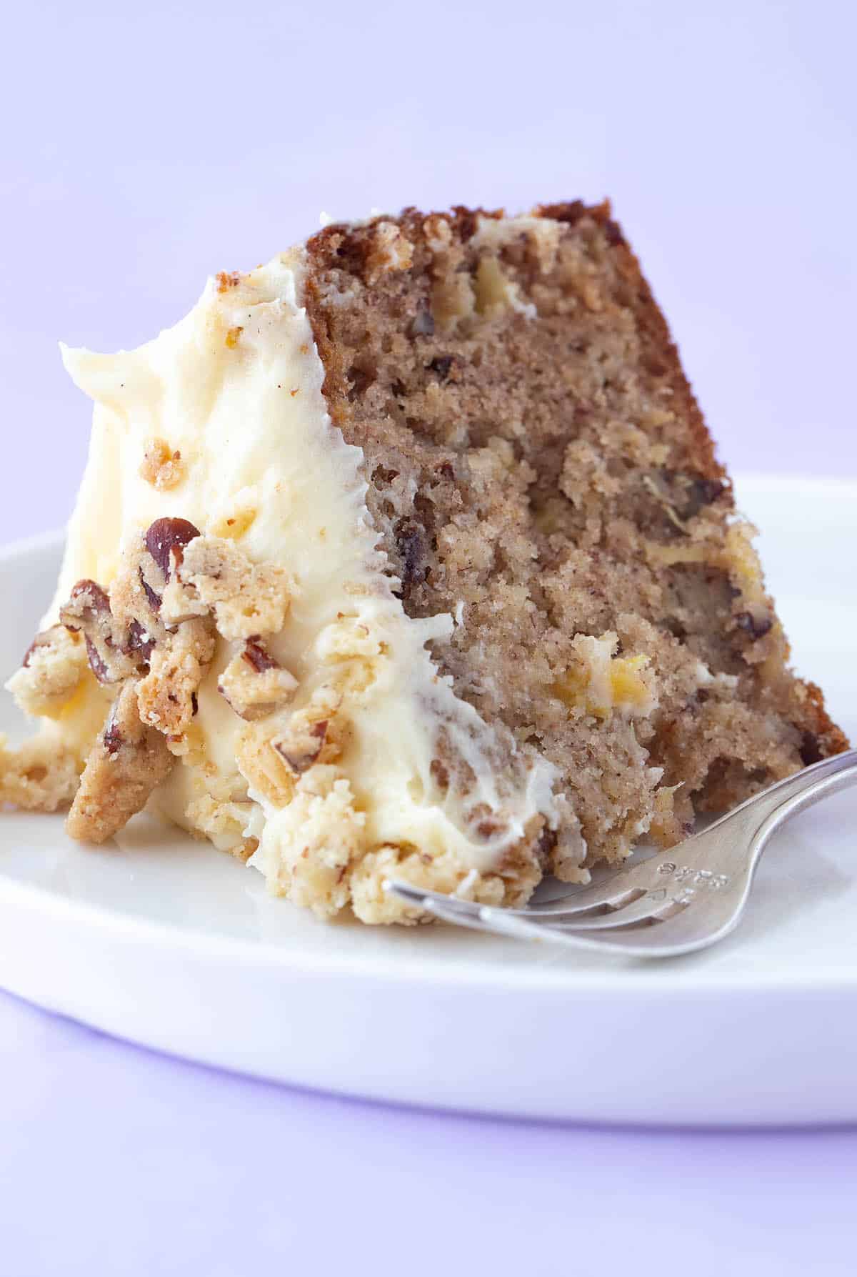 A piece of Hummingbird Cake sitting on a white plate.