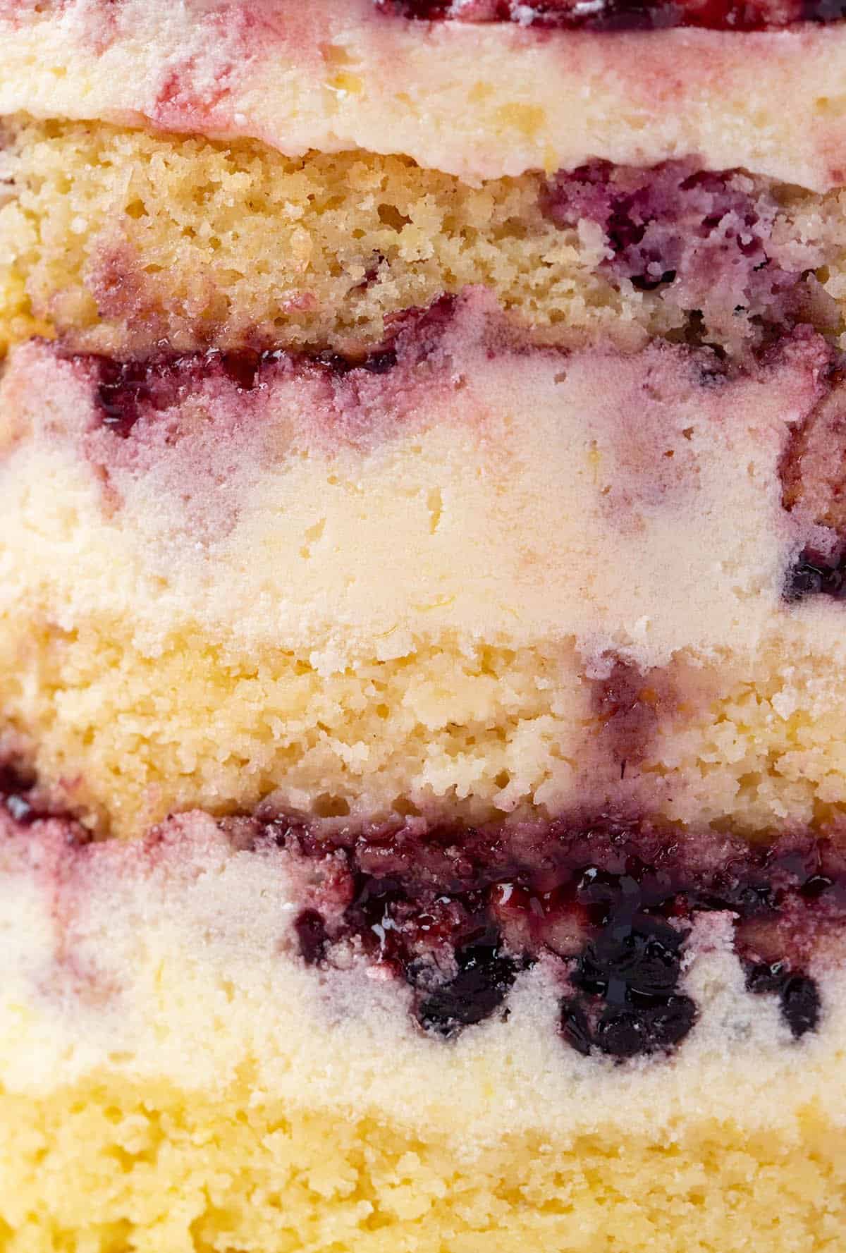 Super close of the amazing layers of a Milk Bar-inspired Lemon Blackberry Cake. 