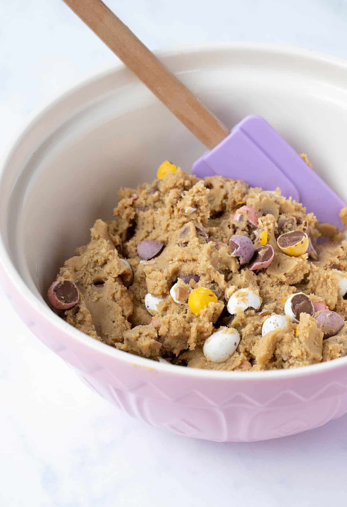 A bowl of homemade Mini Egg Cookie Dough ready to be rolled and baked.