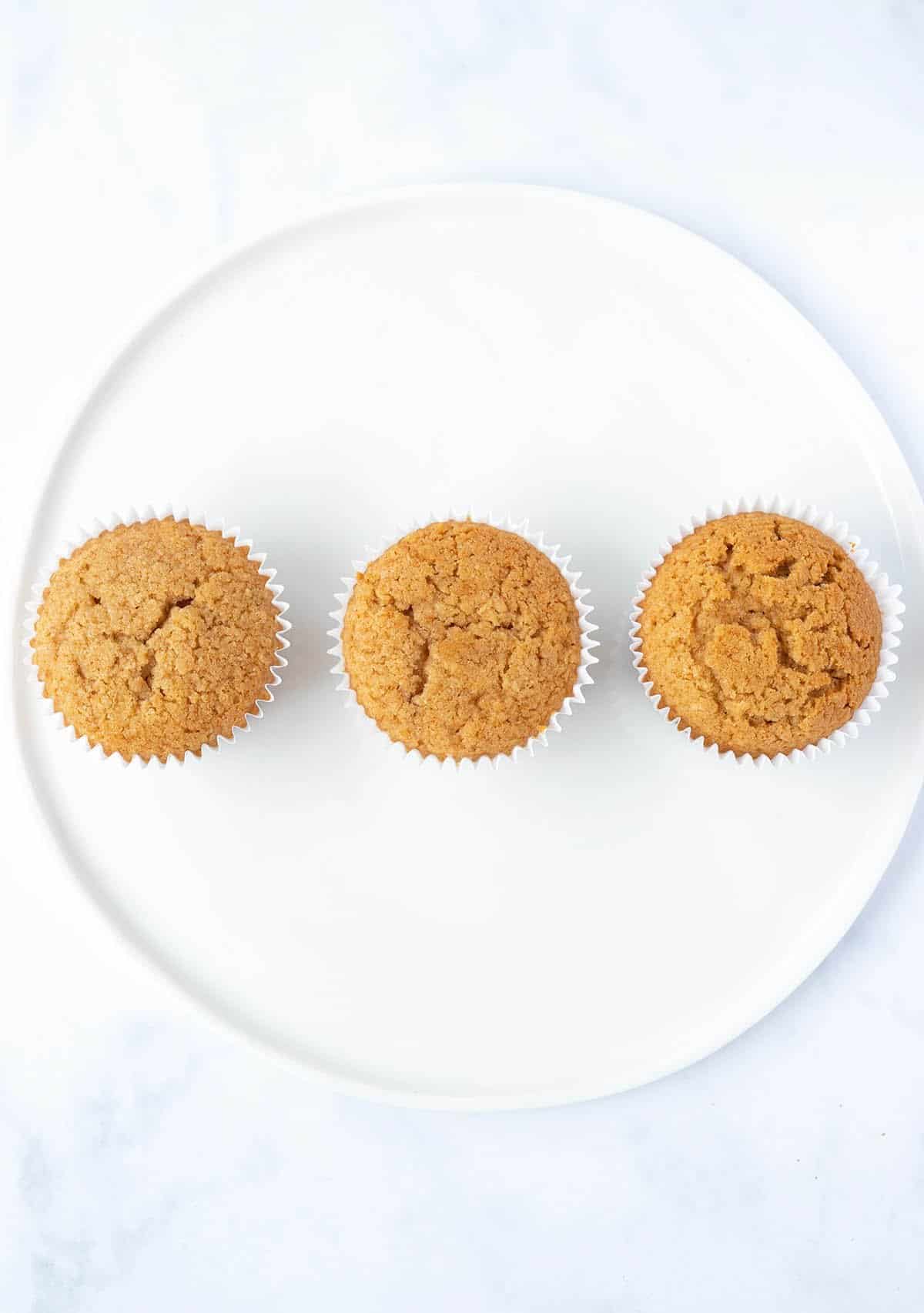 Three Biscoff Cupcakes lined up on a plate showing three different ways of baking.
