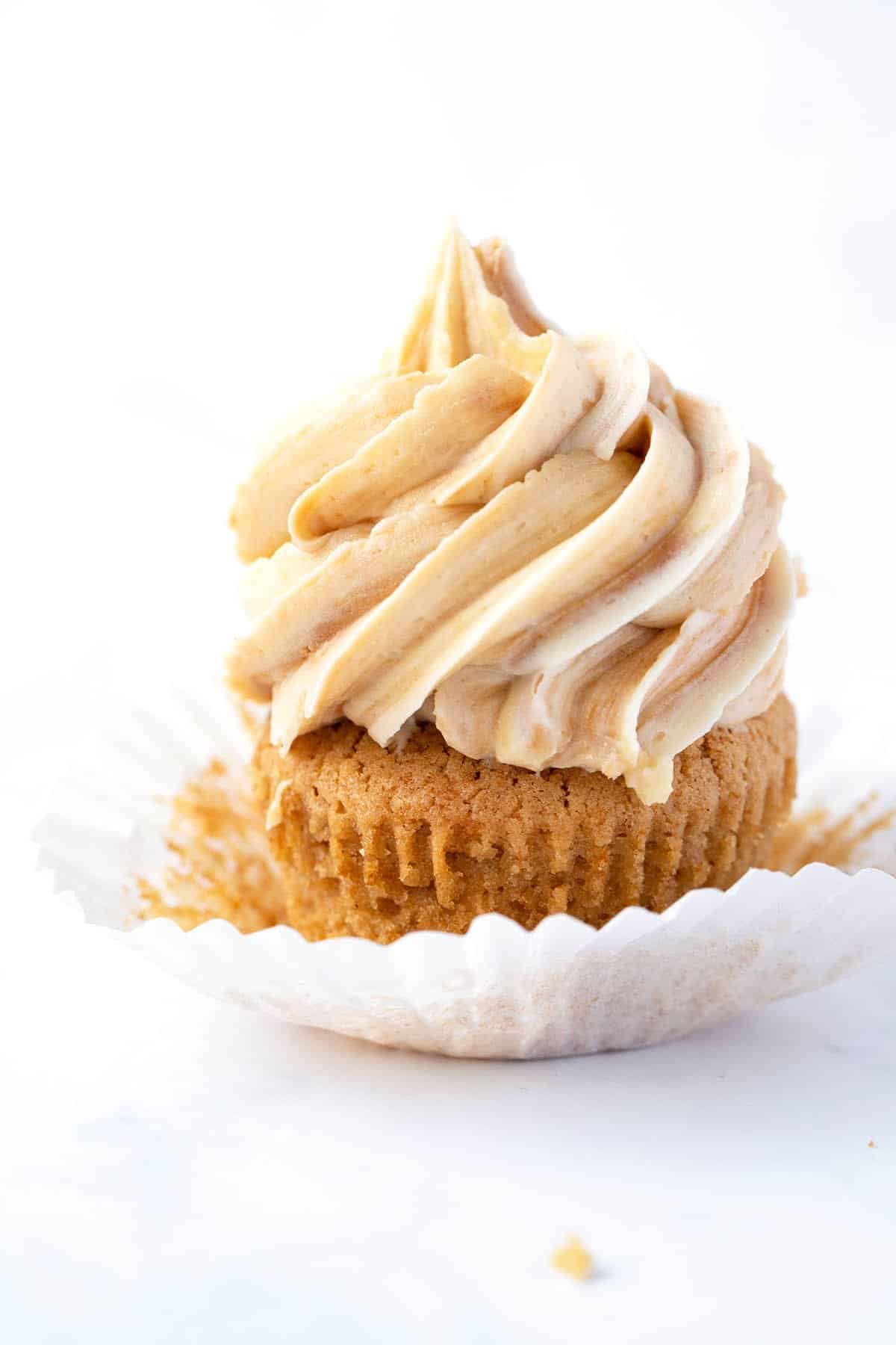 A close up of a Biscoff Cupcakes topped with swirls of buttercream on a white background.