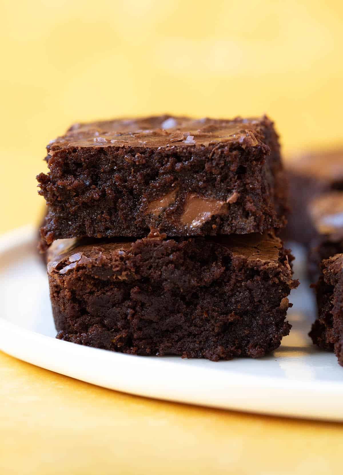 A stack of homemade Chocolate Orange Brownies on a white plate.