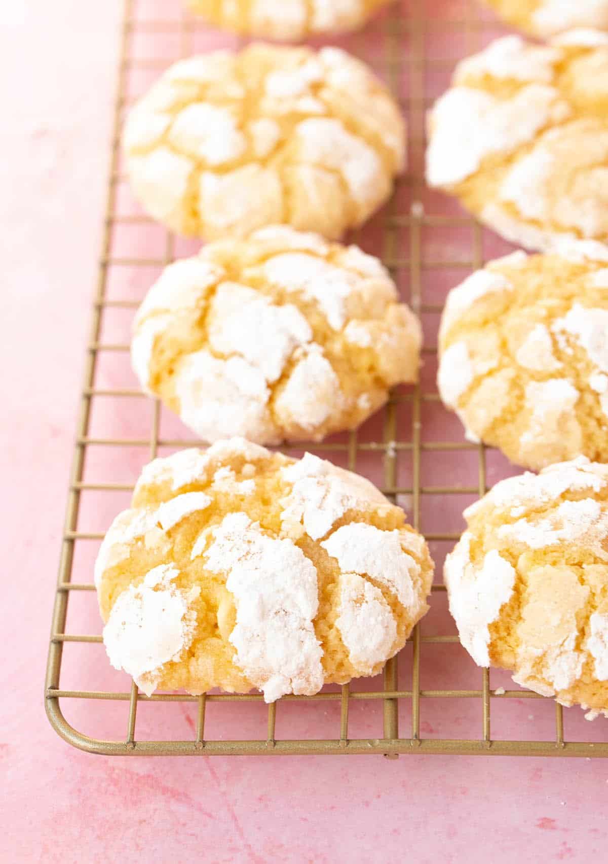 Fresh out of the oven Lemon Cookies on a gold cooling rack.