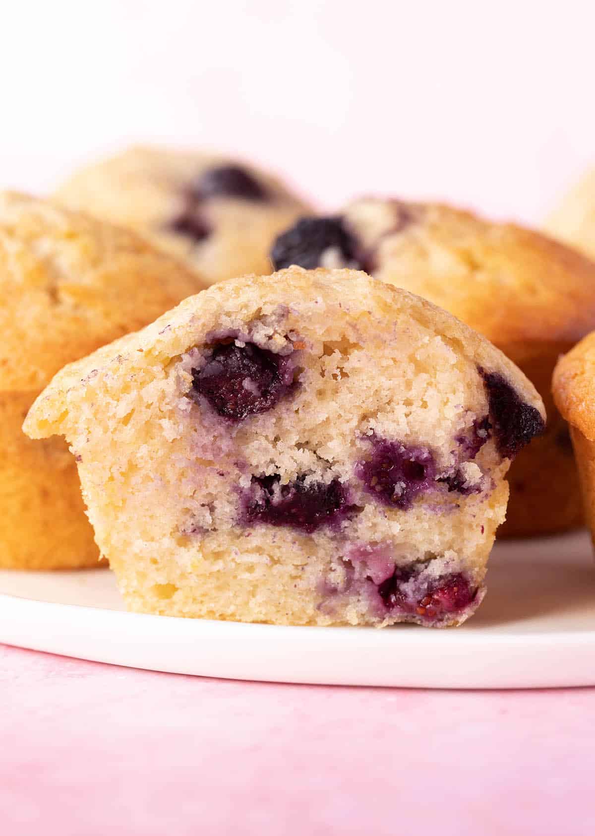 A homemade Lemon Blueberry Muffin sliced in halve showing all the blueberries inside. 