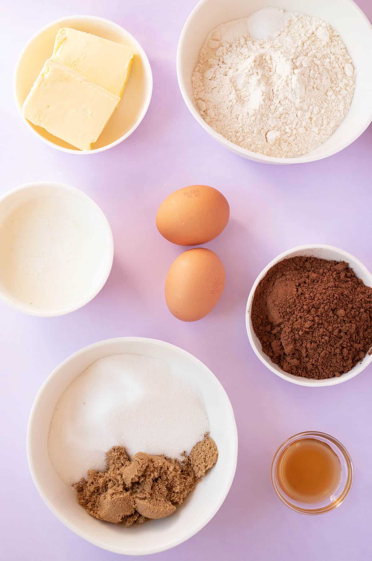 All the ingredients needed to make Nutella Cupcakes at home on a purple background.