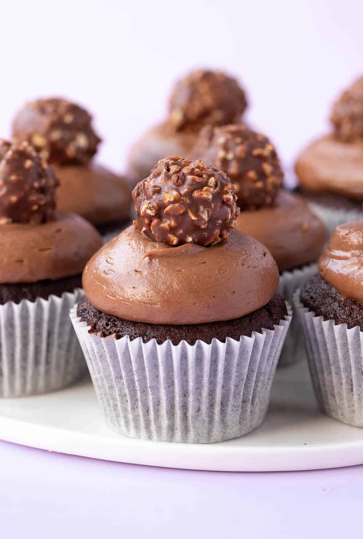 A plate of homemade Nutella Cupcakes decorated with a ferrero rocher.