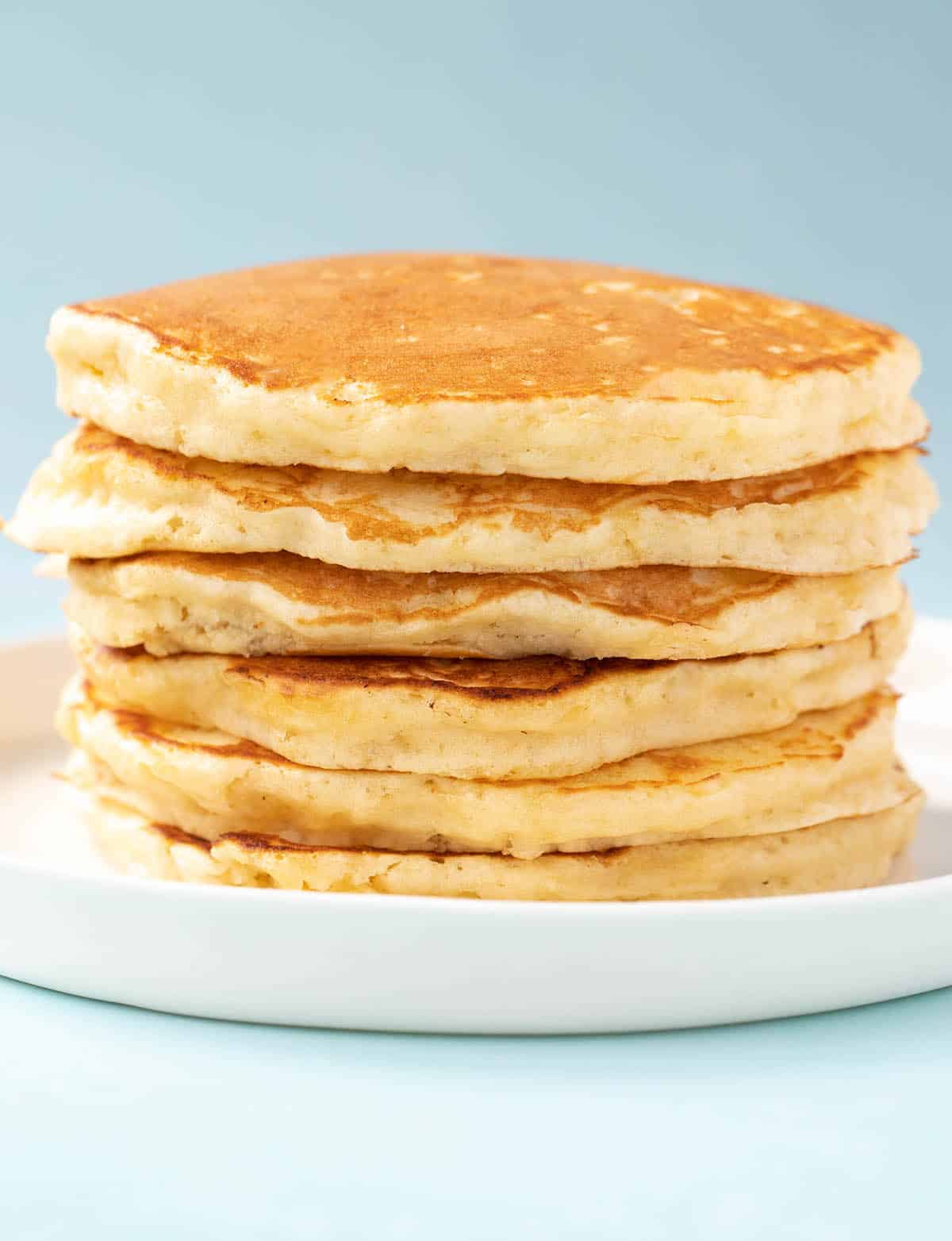 A big stack of Buttermilk Pancakes on a blue background.