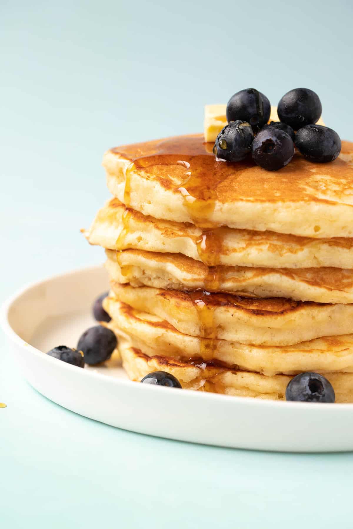 A stack of homemade Buttermilk Pancakes on a white plate. 