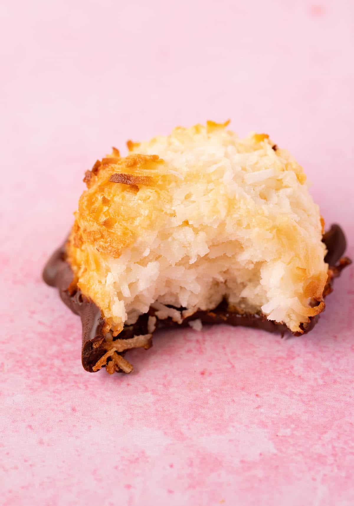 A homemade Coconut Macaroon with a bite taken out of it.