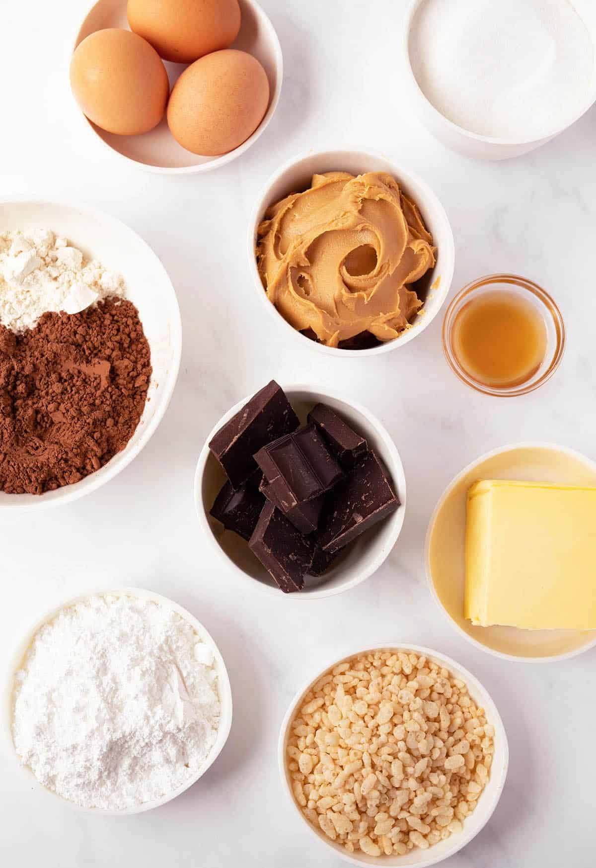 All the ingredients needed to make Peanut Butter Brownie Bars laid out on a marble backdrop.