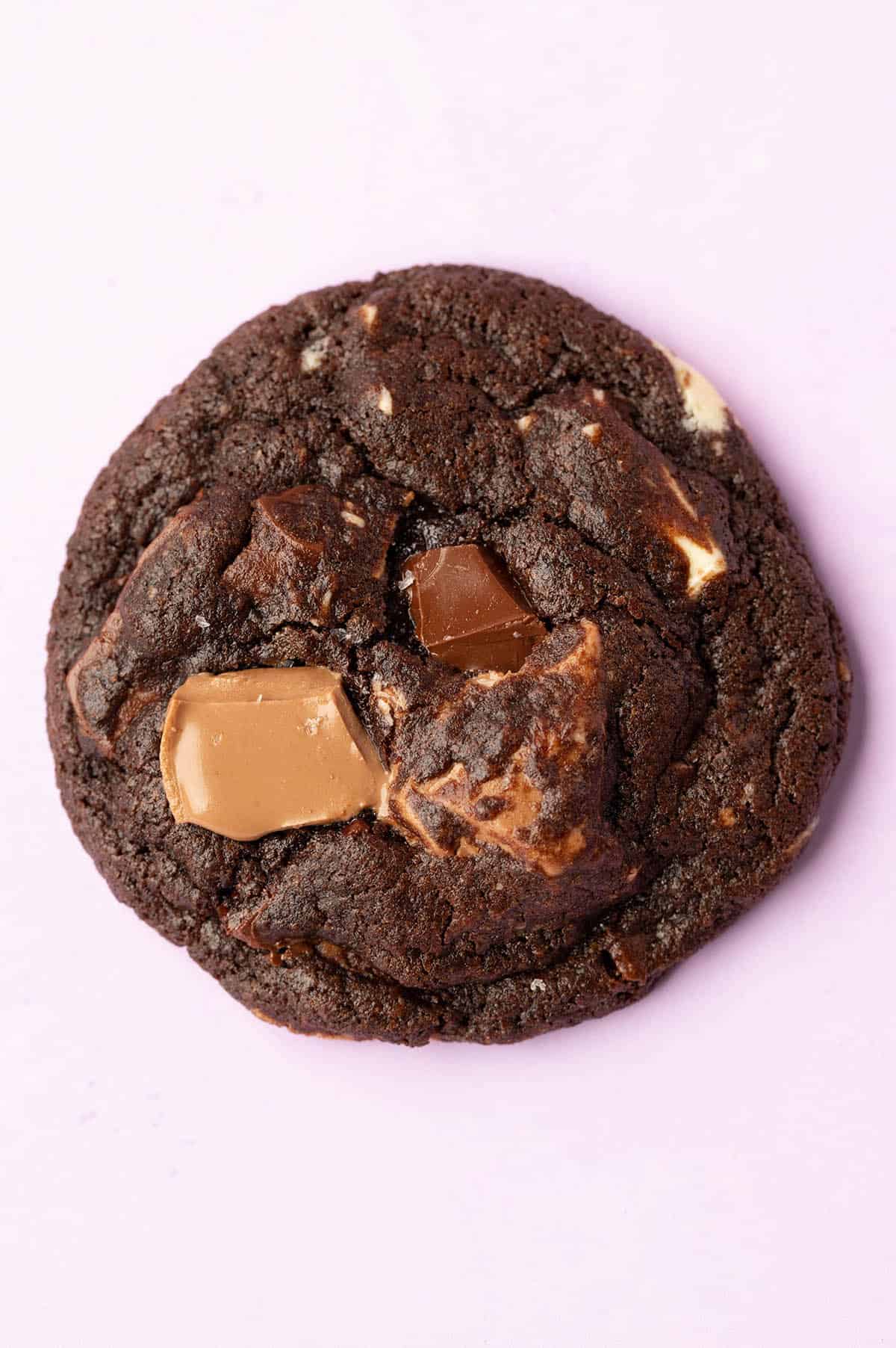 Top view of a Triple Chocolate Cookie sitting on a purple backdrop.