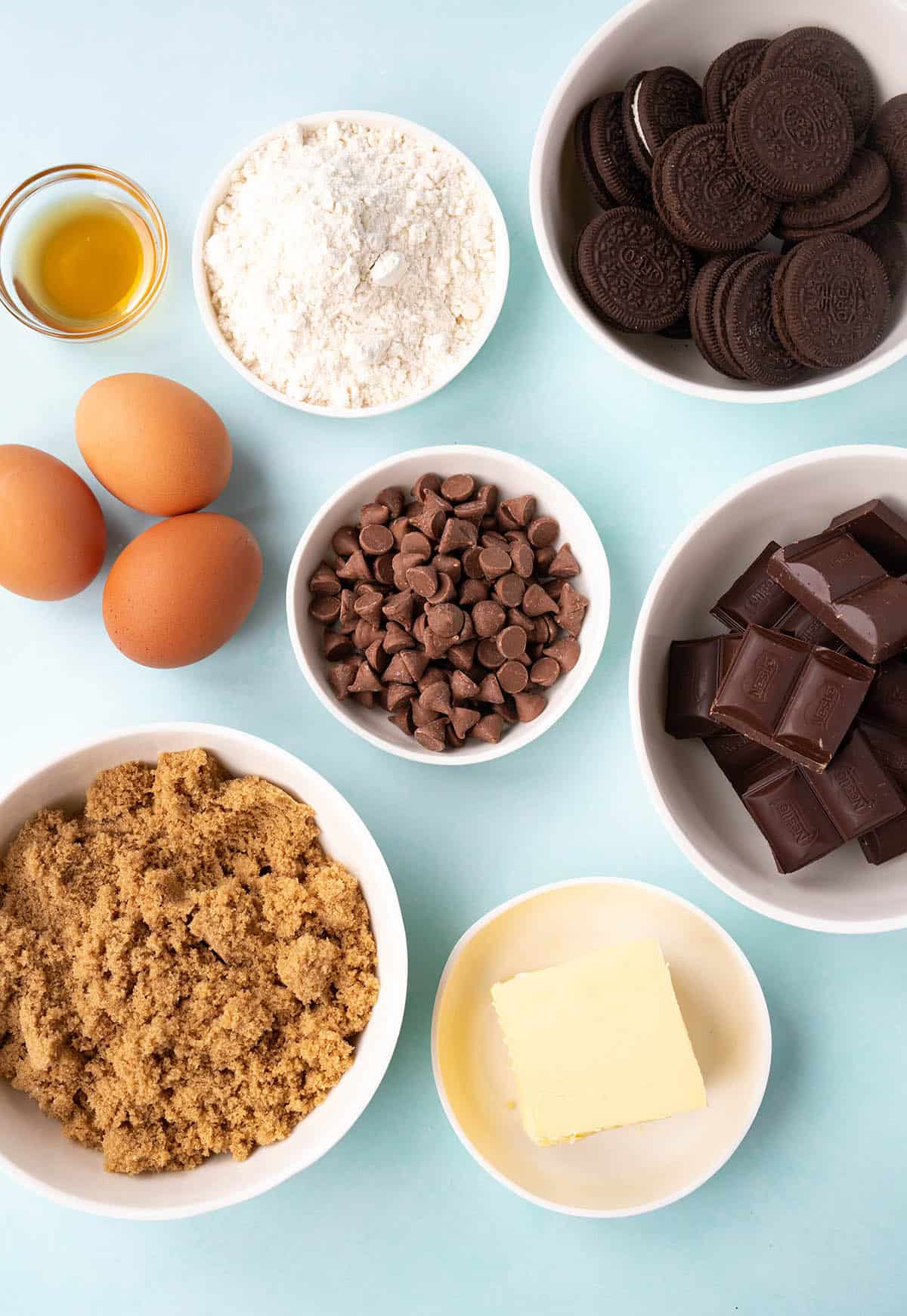 All the ingredients needed to make brownies from scratch on a blue background.